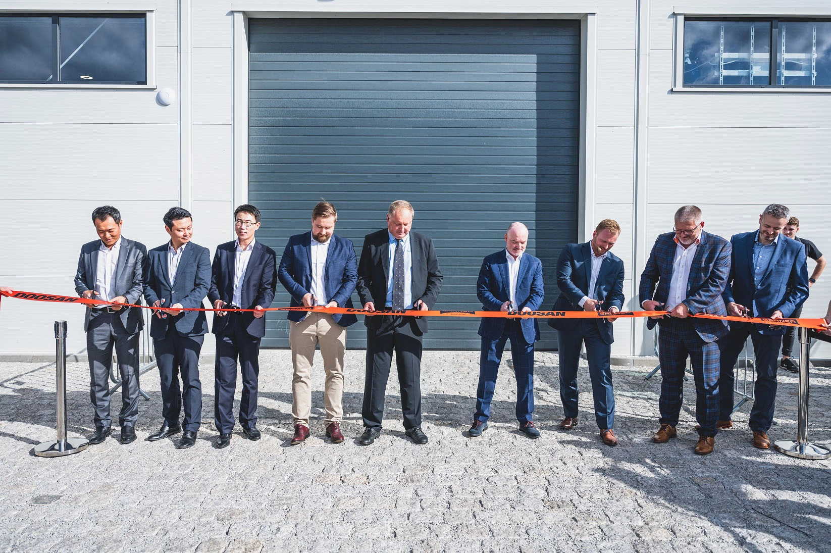 zleva doprava: Yunki Kim, Jae Chang a Sanho Shin, vedení Doosan Infracore Europe, Vojtěch Kratochvíl a Jiří Mácha, manažeři GARNEA, Petr Boukal, regionální zástupce Doosan, Václav Baštýř mladší, jednatel GARNEA, Václav Baštýř starší, zakladatel GARNEA, František Flídr, jednatel GRANITA Lomy